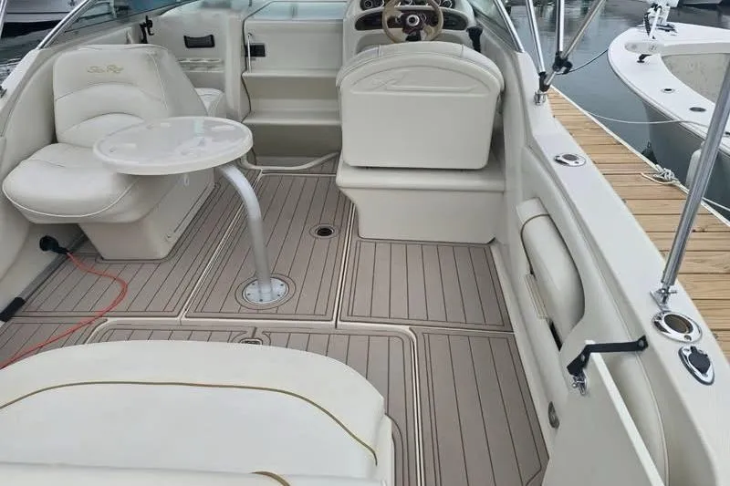 Slide: The Image of 2001 Sea Ray 245 Weekender boat interior with seating and table, docked at marina. - 3