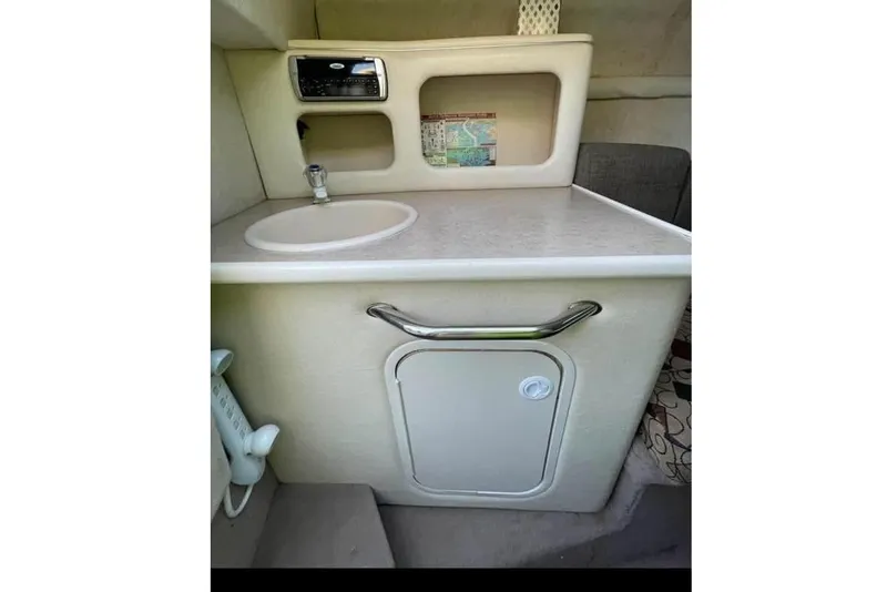 Slide: The Image of 2001 Sea Ray 245 Weekender cabin interior with sink and storage compartment. - 7