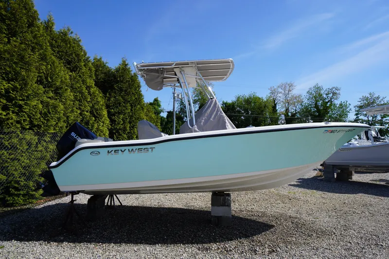 The Image of 2025 Key West 203 FS boat on display, surrounded by greenery and clear blue sky. - 1