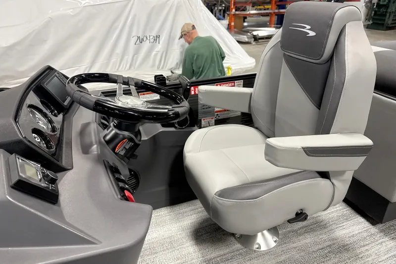 Slide: The Image of 2026 Bennington 22 S Quad Bench boat interior with steering wheel and captain's chair. - 12