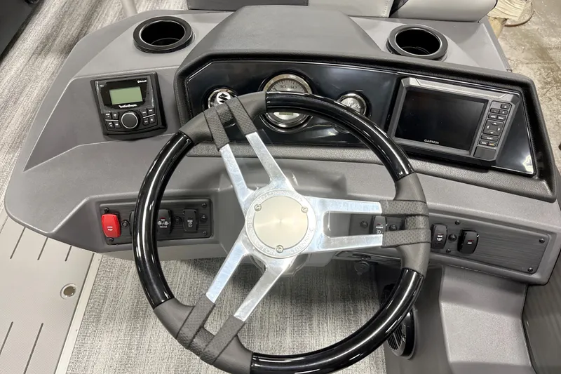 Slide: The Image of Steering console of 2026 Bennington 22 S Quad Bench with modern controls and Garmin display. - 14