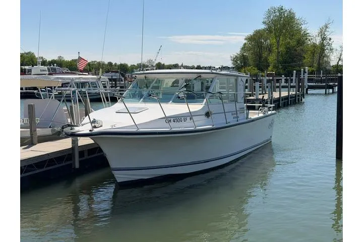 Slide: The Image of 2006 Baha Cruisers 300 GLE boat docked in a marina on a sunny day. - 3