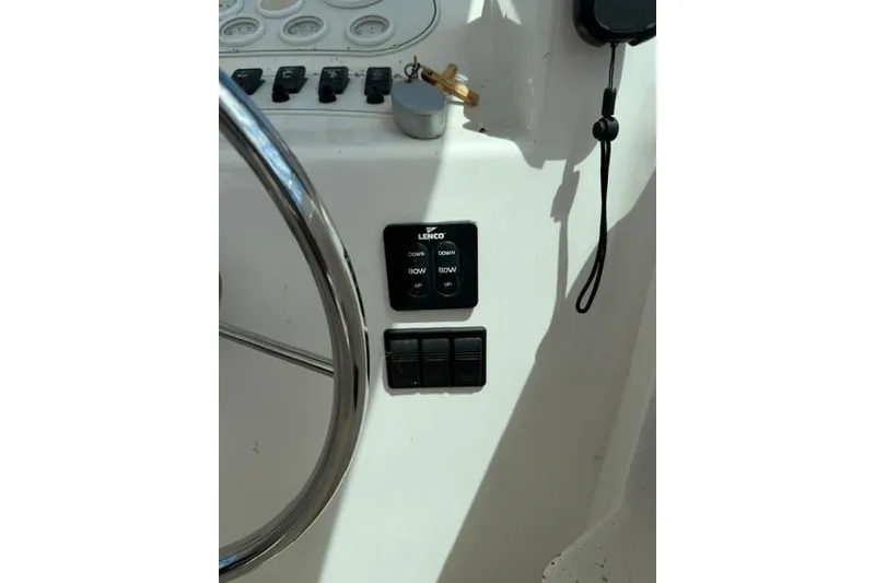 Slide: The Image of Control panel of a 2006 Baha Cruisers 300 GLE boat with steering wheel and switches. - 9
