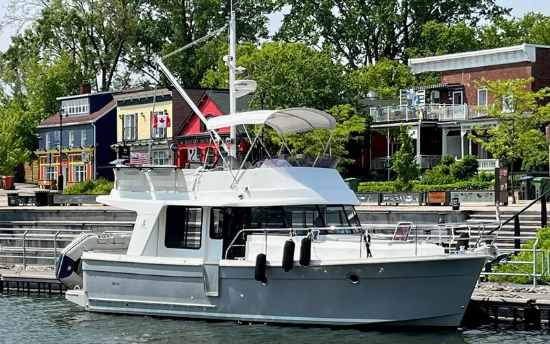 The Image of 2015 Beneteau Swift Trawler 34 Fly docked near colorful buildings. - 0