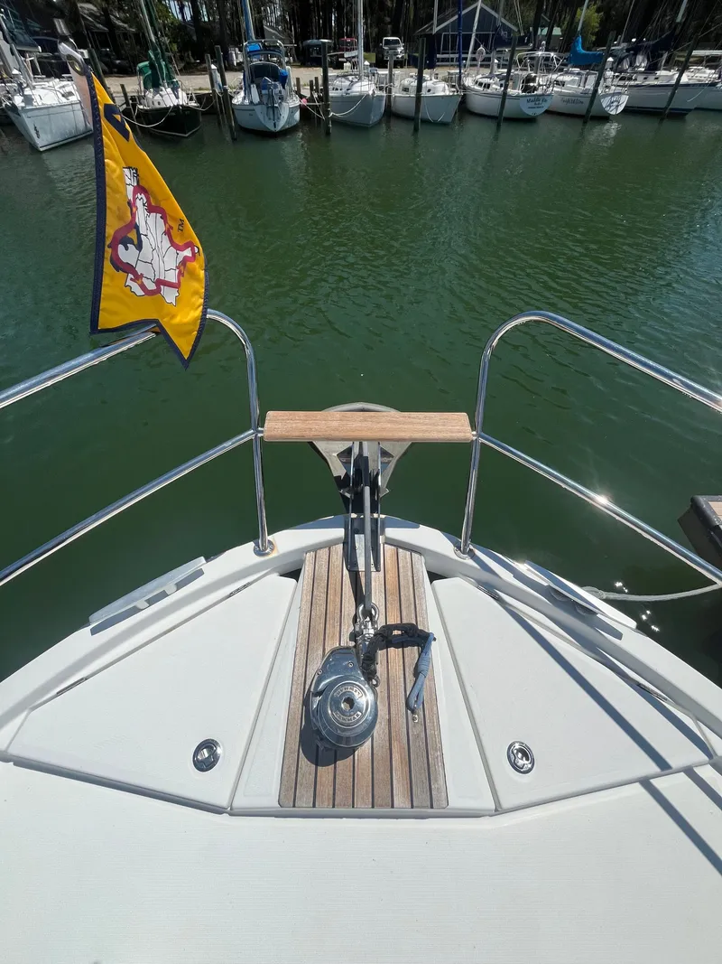 Slide: The Image of Beneteau Swift Trawler 34 Fly, 2015, anchor area with flag in harbor. - 37