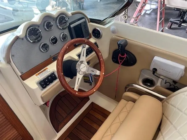 Slide: The Image of 2014 Chris-Craft Corsair 25 cockpit with wooden steering wheel and modern controls. - 10