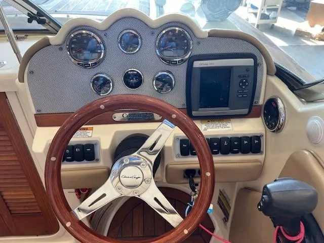 Slide: The Image of 2014 Chris-Craft Corsair 25 dashboard with wooden steering wheel and navigation instruments. - 11