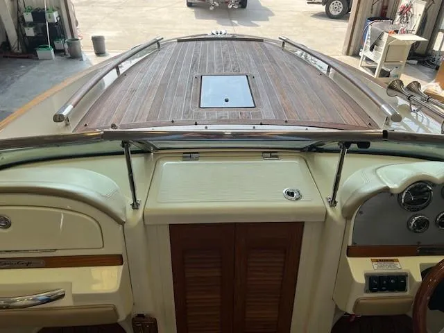 Slide: The Image of 2014 Chris-Craft Corsair 25 boat interior with wooden deck and control panel. - 13