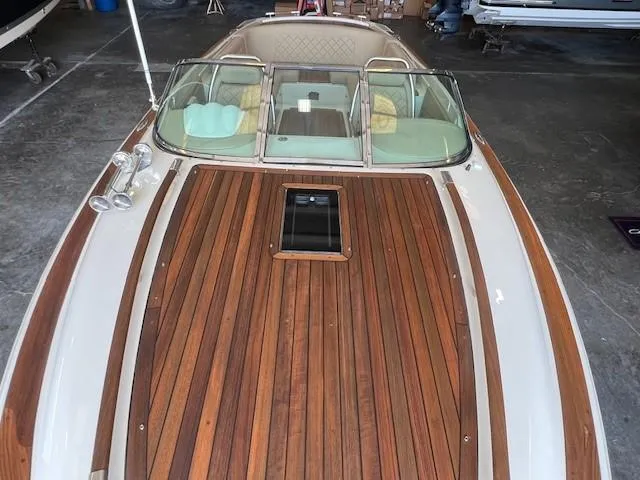 Slide: The Image of 2014 Chris-Craft Corsair 25 with elegant wooden deck in a showroom. - 16