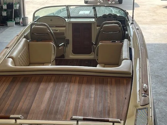 Slide: The Image of 2014 Chris-Craft Corsair 25 boat interior with wood deck and leather seats. - 2