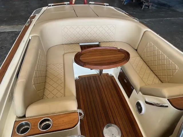 Slide: The Image of Luxurious 2014 Chris-Craft Corsair 25 boat interior with elegant seating and wooden table. - 22