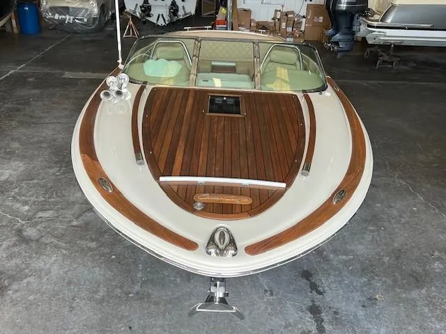 Slide: The Image of 2014 Chris-Craft Corsair 25 boat with elegant wood detailing in a garage setting. - 3