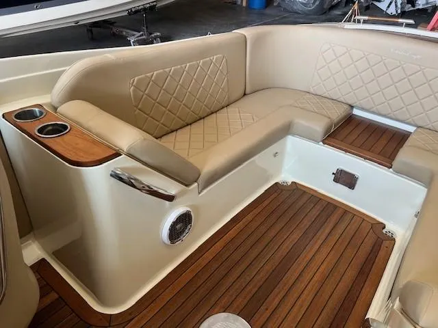 Slide: The Image of 2014 Chris-Craft Corsair 25 interior with beige leather seating and wooden flooring. - 9