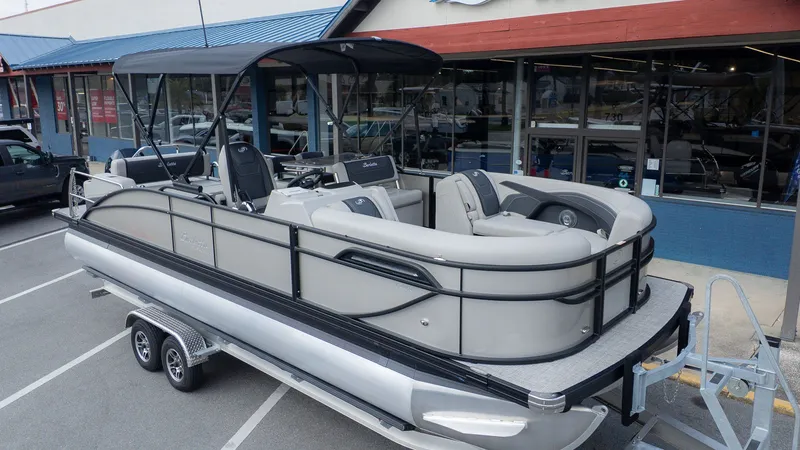 Slide: The Image of 2026 Barletta Cabrio 24UE pontoon boat on trailer outside store. - 3