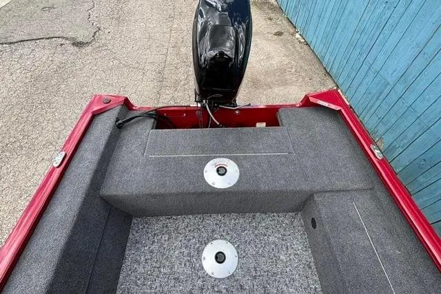 Slide: The Image of 2025 Tracker Super Guide V-16 SC boat interior with motor, red and gray design. - 13