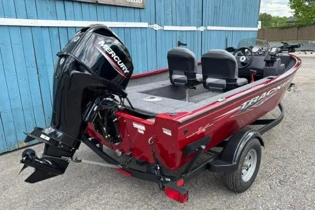 Slide: The Image of 2025 Tracker Super Guide V-16 SC boat with Mercury engine, parked on a trailer. - 2