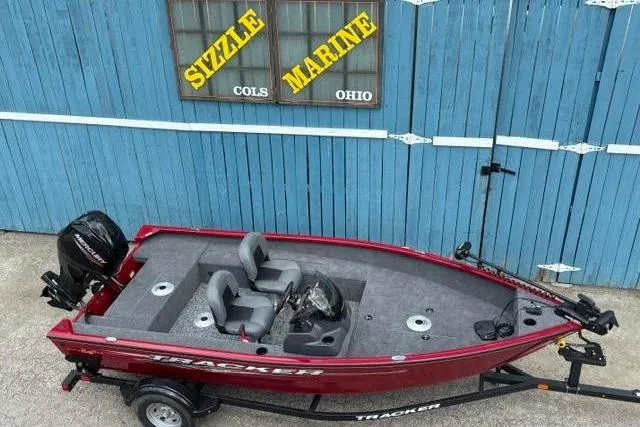 Slide: The Image of 2025 Tracker Super Guide V-16 SC boat in front of blue garage, Sizzle Marine sign. - 5