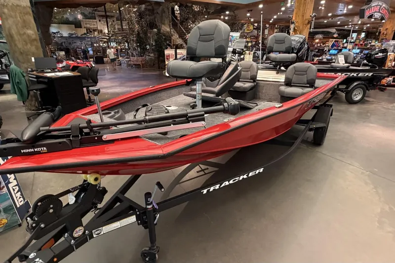 Slide: The Image of 2026 Tracker Pro Team 175 Crappie Edition boat displayed indoors, featuring red exterior and multiple seats. - 2