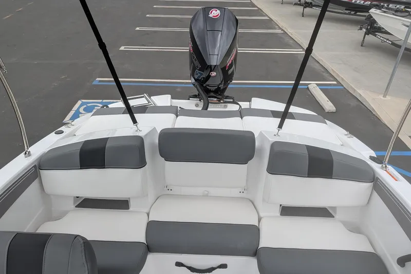 Slide: The Image of 2026 Tahoe T21 boat interior with seating and outboard motor in parking lot. - 9