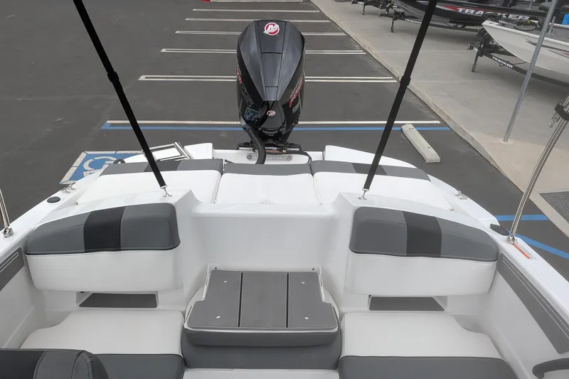 Slide: The Image of 2026 Tahoe T21 boat interior with seating and outboard motor in a parking lot. - 7