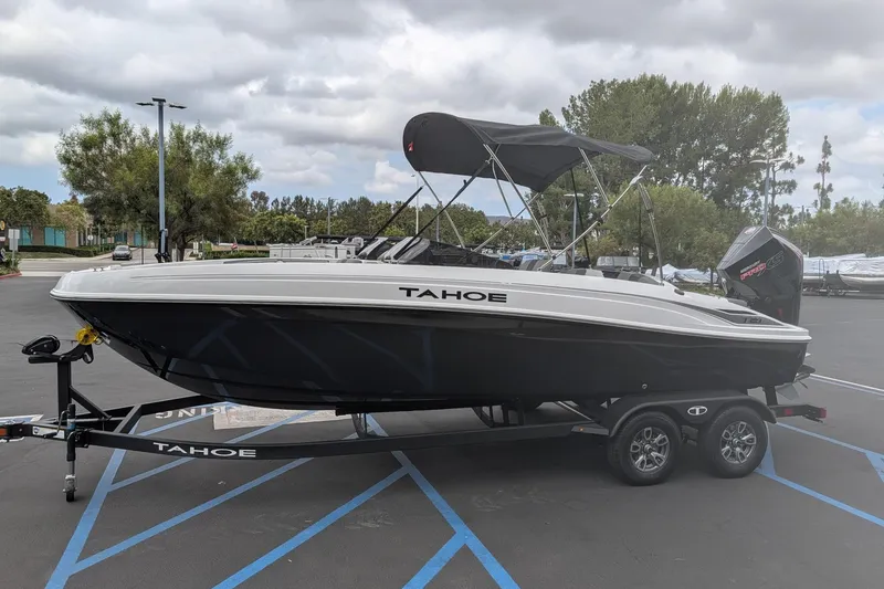 Slide: The Image of 2026 Tahoe T21 boat on trailer in parking lot, under cloudy sky. - 5