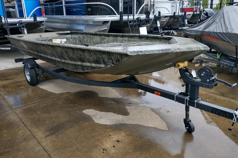 The Image of 2026 Tracker Grizzly 1648 Utility boat on trailer, displayed outdoors on wet pavement. - 0