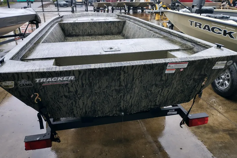 Slide: The Image of 2026 Tracker Grizzly 1648 Utility boat on trailer, camo design, parked outdoors. - 3