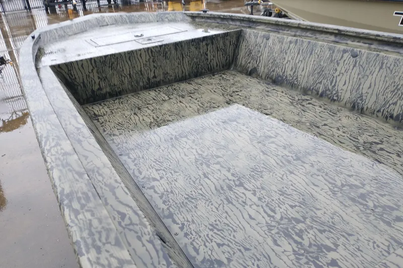 Slide: The Image of 2026 Tracker Grizzly 1648 Utility boat interior with camouflage pattern, wet from rain. - 4