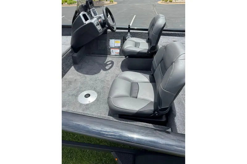 Slide: The Image of 2026 Tracker Pro Team 175 Crappie Edition boat interior with gray seating and steering console. - 8