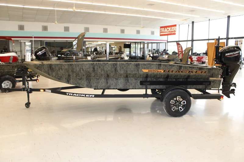 The Image of 2026 Tracker Grizzly 1756 T Marsh boat displayed in showroom with Mercury engine. - 0