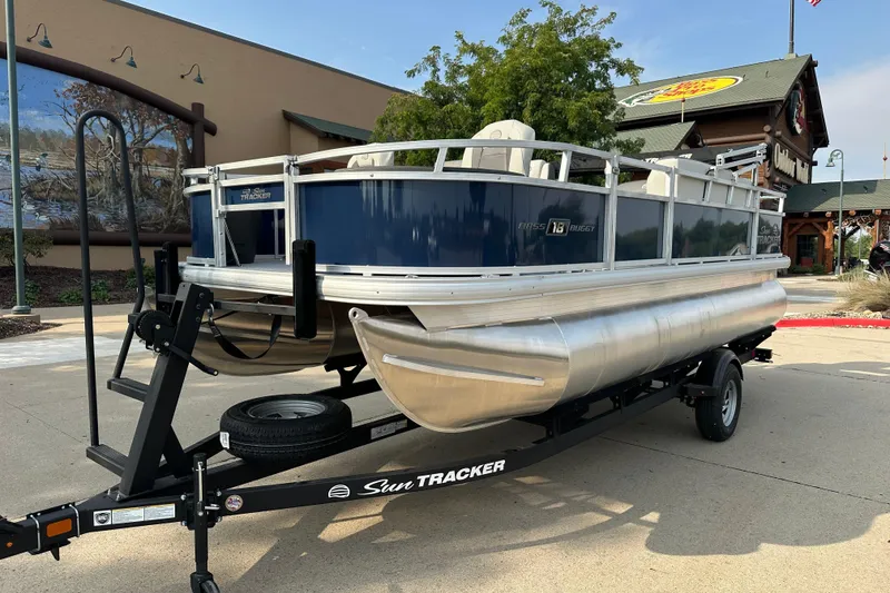 The Image of 2026 Sun Tracker Bass Buggy 18 DLX pontoon boat on trailer, outdoor setting. - 0