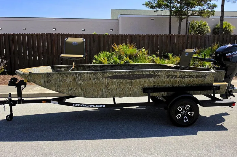 Slide: The Image of 2026 Tracker Grizzly 1650 T Prairie Wings Edition boat on trailer, camo design, parked outdoors. - 4