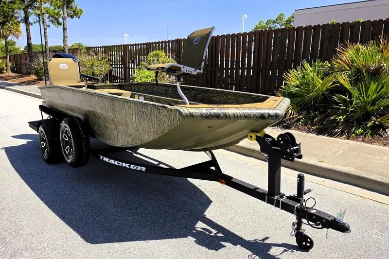 Slide: The Image of 2026 Tracker Grizzly 1650 T Prairie Wings Edition boat on trailer, parked outdoors. - 2