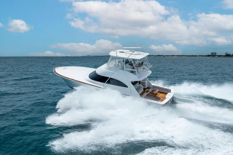 Slide: The Image of 2026 Viking 54 Convertible yacht cruising on open ocean under clear skies. - 11