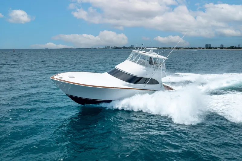 Slide: The Image of 2026 Viking 54 Convertible yacht cruising on open ocean under blue sky. - 12