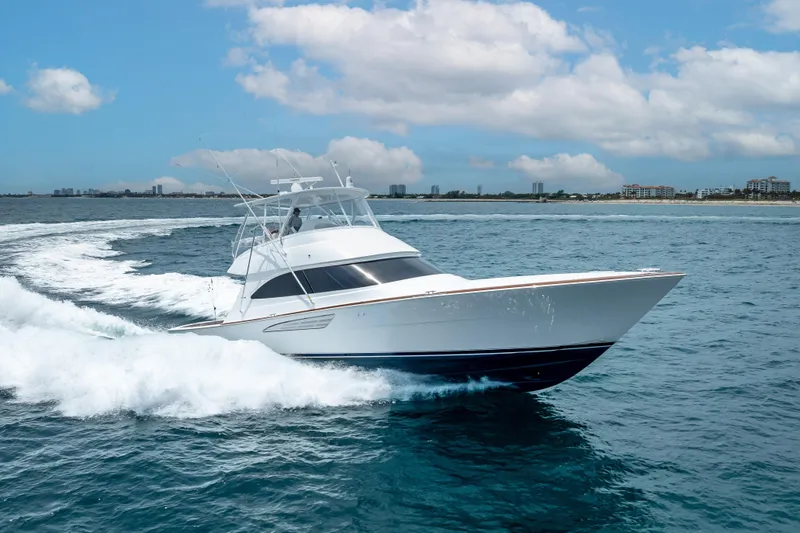 Slide: The Image of 2026 Viking 54 Convertible yacht cruising on open water under a partly cloudy sky. - 14