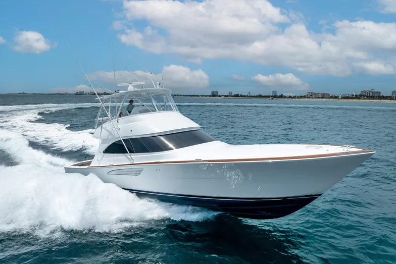 Slide: The Image of 2026 Viking 54 Convertible yacht cruising on open water under a partly cloudy sky. - 15