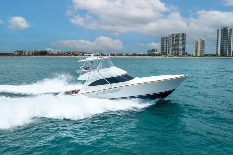 Slide: The Image of 2026 Viking 54 Convertible yacht cruising on ocean near city skyline. - 17