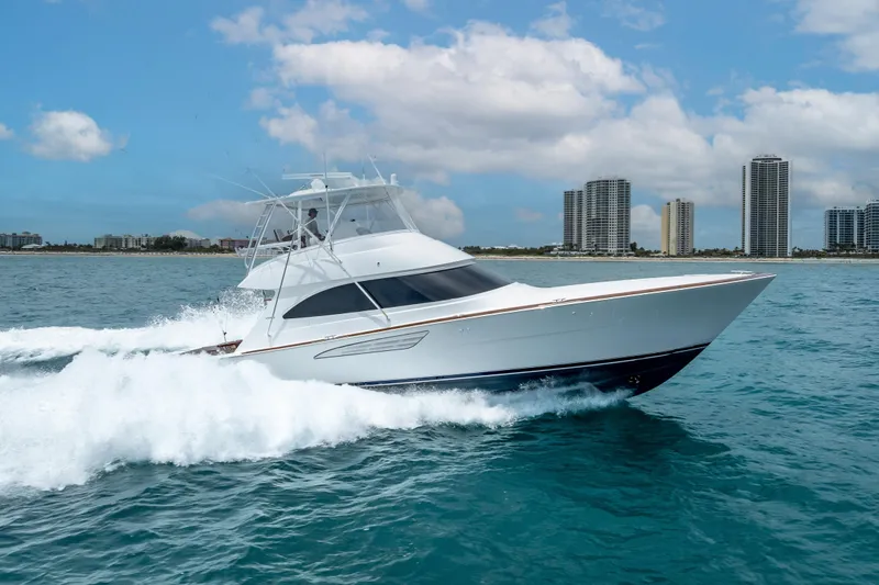 Slide: The Image of 2026 Viking 54 Convertible yacht cruising on ocean near city skyline. - 18