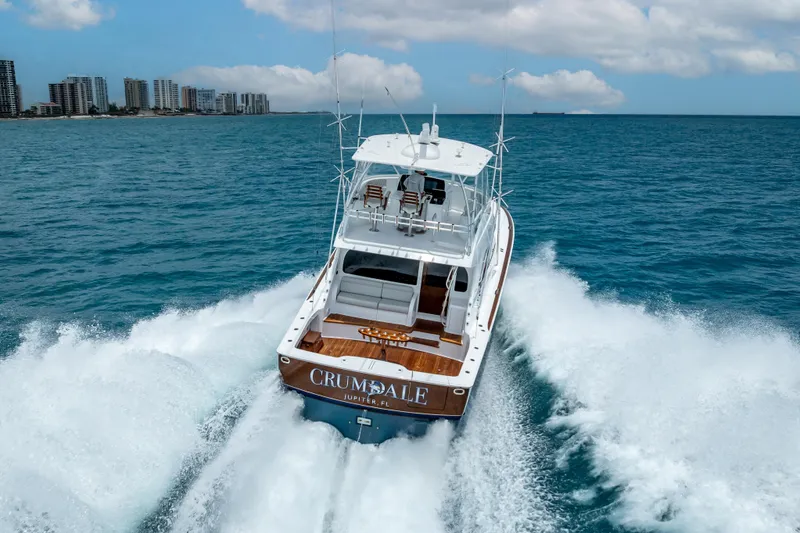 Slide: The Image of 2026 Viking 54 Convertible yacht cruising in open ocean near city skyline. - 20
