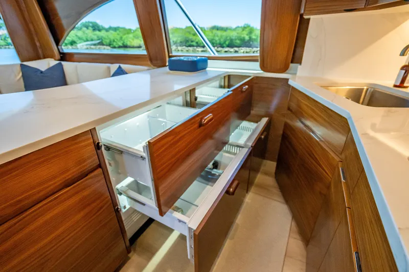 Slide: The Image of Luxurious interior of 2026 Viking 54 Convertible yacht with open wooden cabinets and modern design. - 38