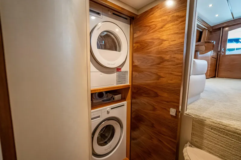 Slide: The Image of Laundry area in 2026 Viking 54 Convertible yacht with stacked washer and dryer. - 52