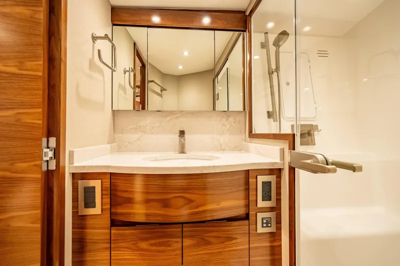 Slide: The Image of Luxurious bathroom interior of 2026 Viking 54 Convertible yacht with wood accents and modern fixtures. - 53
