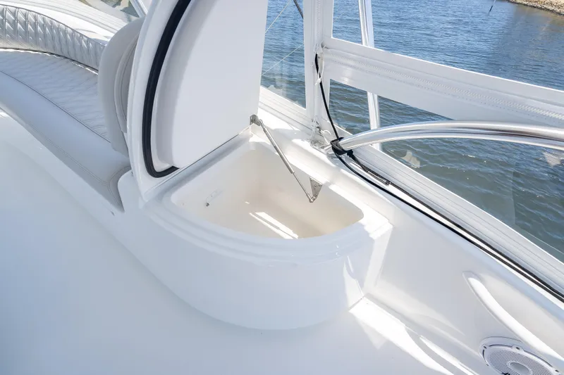 Slide: The Image of 2026 Viking 54 Convertible yacht interior with open storage compartment, overlooking water. - 61