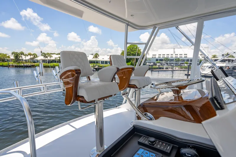 Slide: The Image of Luxury helm station on 2026 Viking 54 Convertible yacht, featuring elegant seating and controls. - 62