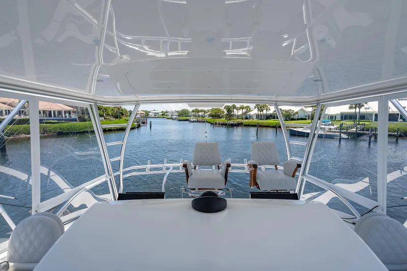 Slide: The Image of Flybridge view of 2026 Viking 54 Convertible yacht overlooking serene marina. - 67