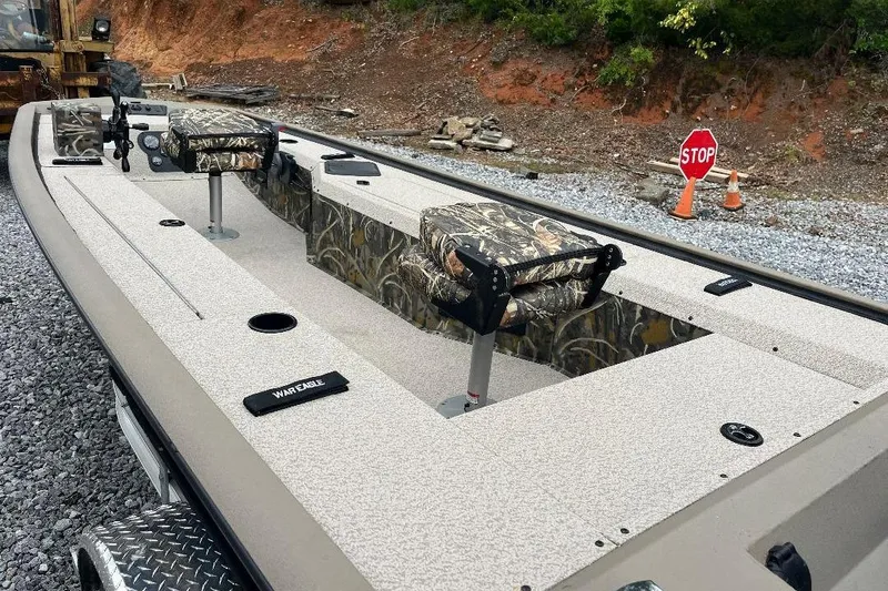 Slide: The Image of 2026 War Eagle 754VS Stick Steer boat with camouflage seats on gravel surface. - 10