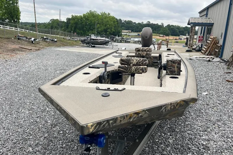 Slide: The Image of 2026 War Eagle 754VS Stick Steer boat on gravel, featuring camouflage seating. - 11