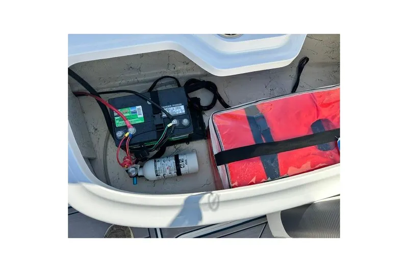 Slide: The Image of 2021 Hurricane SunDeck Sport 185 OB storage compartment with battery and safety equipment. - 20