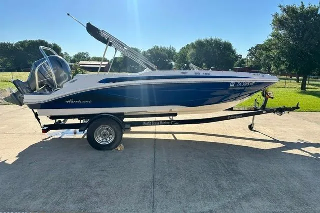 Slide: The Image of 2021 Hurricane SunDeck Sport 185 OB boat on trailer, parked outdoors in sunny setting. - 3